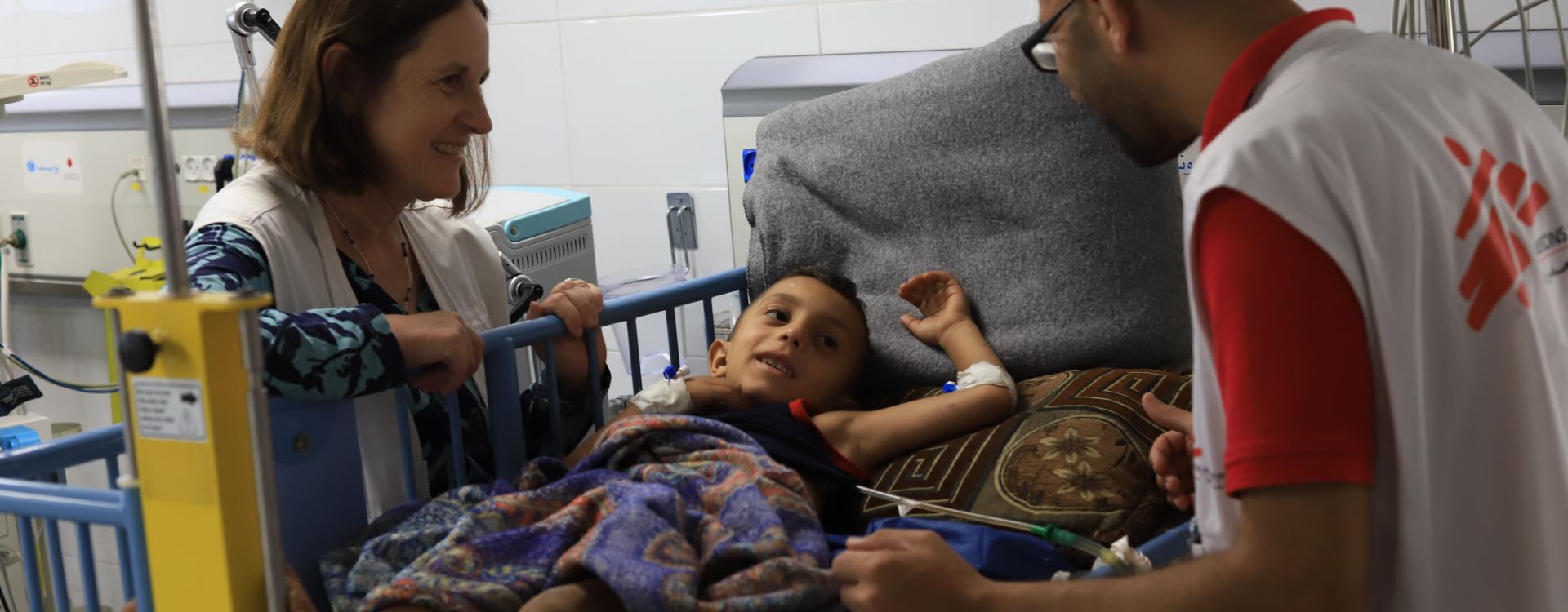 Mohammad Shihada, Nurse Team Supervisor, and Joanne Perry, Project Medical Referent in Gaza, checking on a a patient receiving treatment after being injured in Gaza.