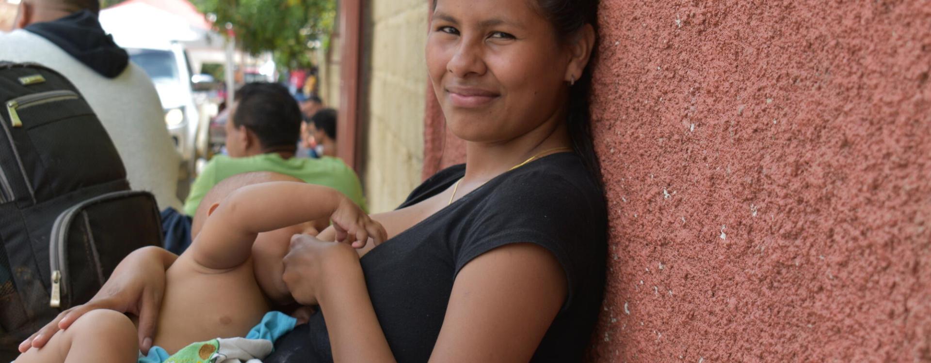 La hija mayor de la familia Brito amamanta a su hijo mientras espera que su familia reciba consulta médica.