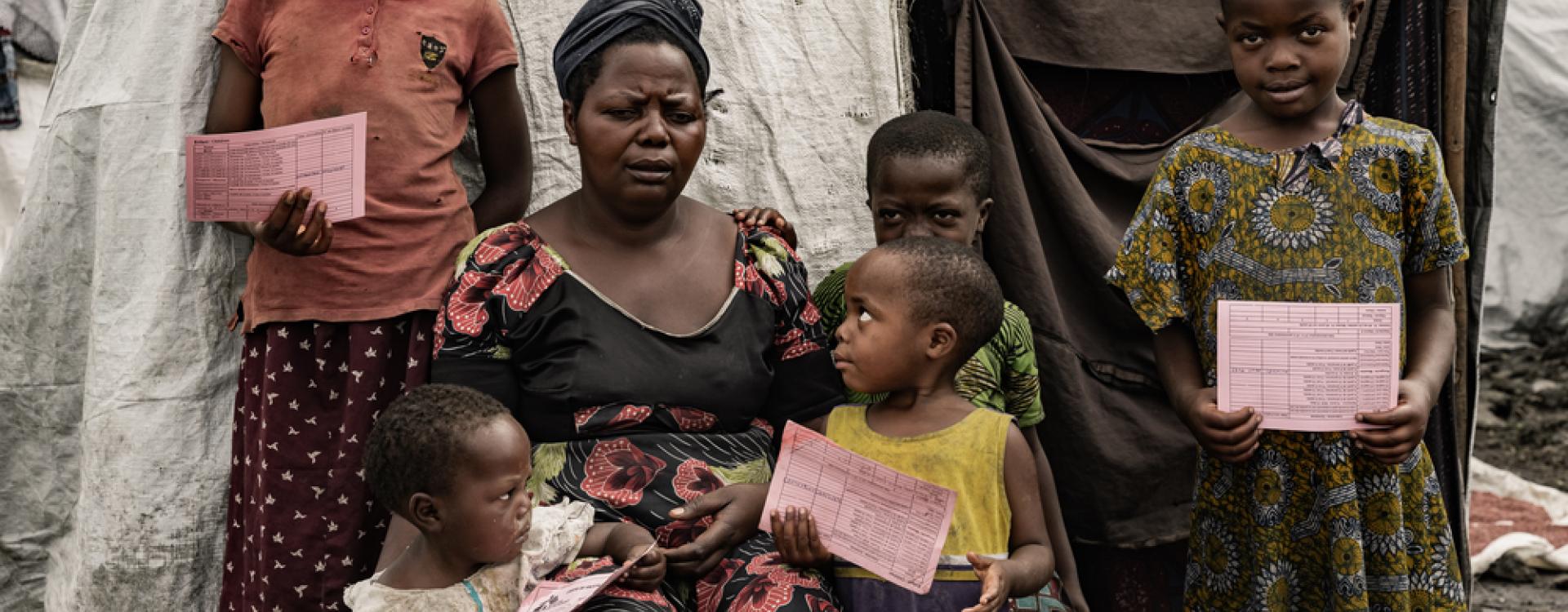 Bora Bandoraho con sus hijos y sus carnés de vacunación en Kanyaruchinya, RDC