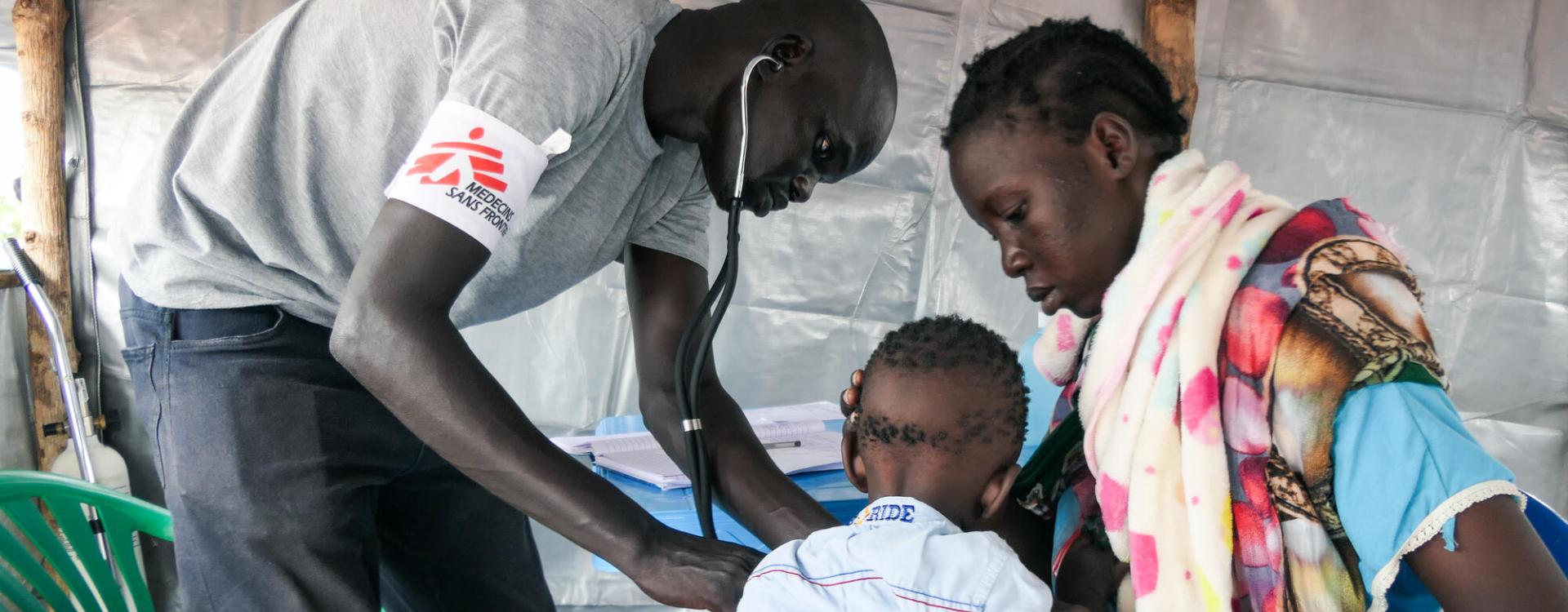 El oficial clínico Chuol Hoth examina a un niño en la clínica móvil de MSF en el centro de tránsito de Bulukat, Sudán del Sur.  