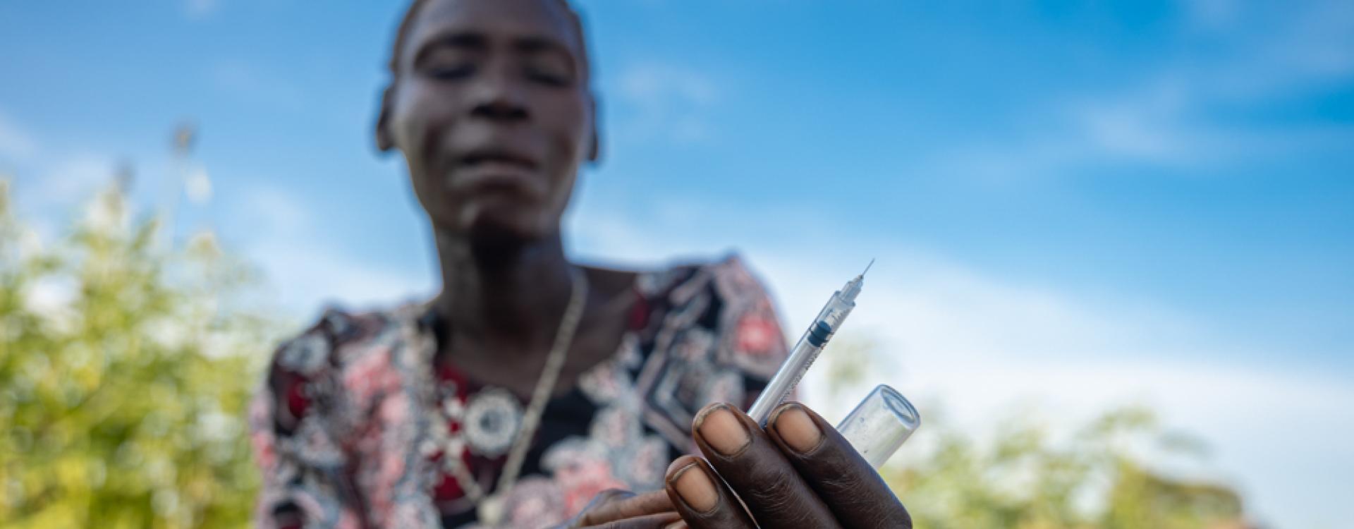 Rebecca muestra cómo utiliza una jeringuilla para administrarle insulina a su hijo Ajou, de 12 años.