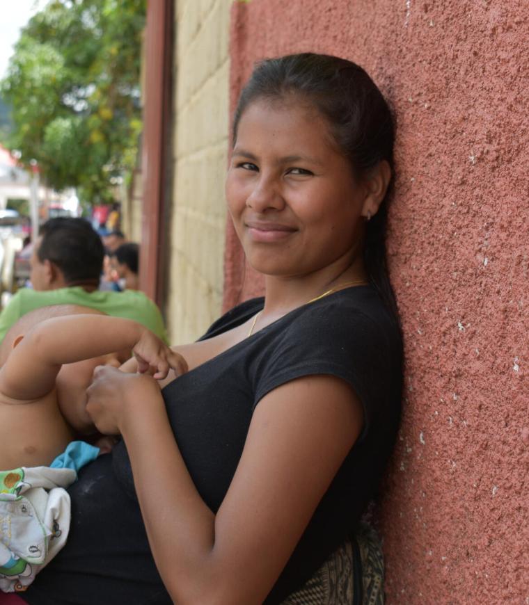 La hija mayor de la familia Brito amamanta a su hijo mientras espera que su familia reciba consulta médica.