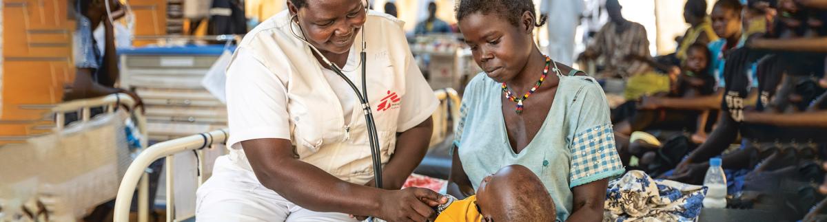 La enfermera supervisora Scovia Morris examina al niño de 13 meses Chan Akok. Aweil, Sudán de Sur, agosto de 2023.