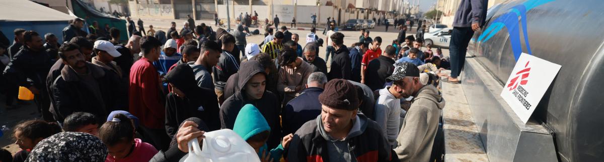 Un grupo de palestinos desplazados recibe agua de un camión de MSF en el barrio saudí de Rafah, al sur de Gaza.