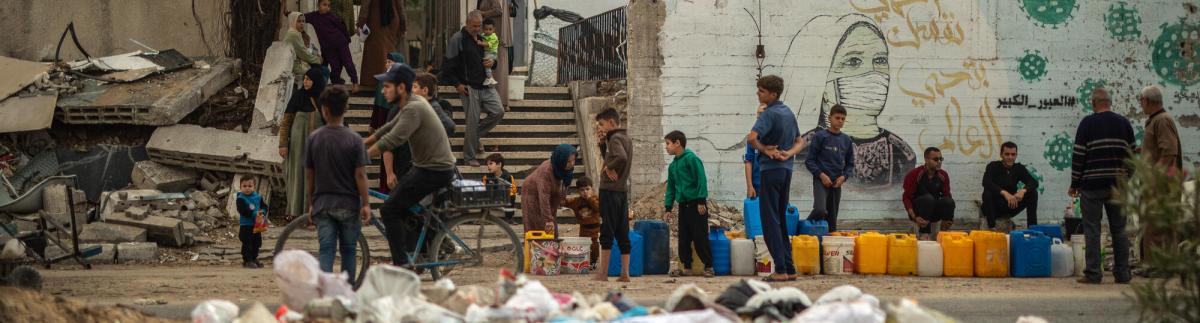 En la calle Al Jalaa de la ciudad de Gaza, la gente hace cola para recoger agua.