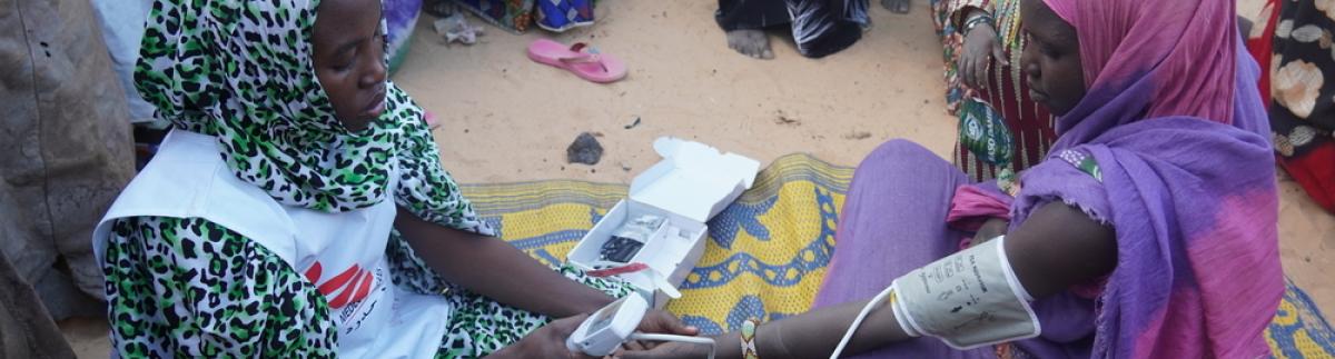 Una matrona de MSF toma la tensión arterial a una mujer embarazada en un campamento de personas desplazadas en Ansongo, al norte de Mali.