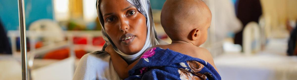 Suado Hassan Mohamed, de 22 años, sostiene a su hijo de 11 meses, Abdirahman Abdilatif, en la sala de pediatría del Hospital Regional de Bay.