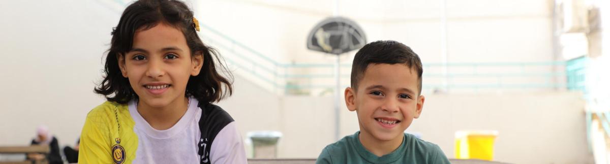Omar está sentado con su hermana en el patio del hospital de cirugía reconstructiva de Amán, Jordania. 