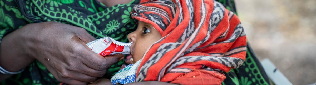 Igahale, de 13 meses, come un sobre de alimento terapéutico