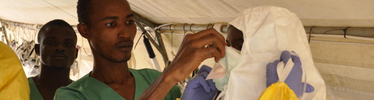 Los miembros del equipo médico se visten con el equipo de protección antes de entrar en el recinto.