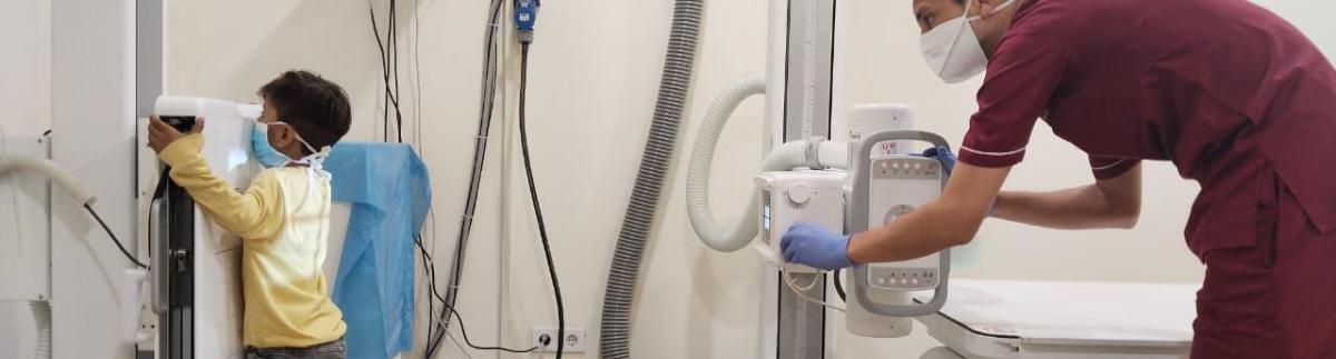 Un técnico de radiología de MSF está realizando una radiografía a un niño en la clínica de tuberculosis de MSF del Centro de Salud Rural de Baldia, en Karachi, durante una revisión médica.