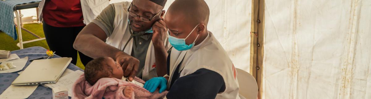 La consejera Nosisipho Zozi observa mientras el doctor Adebayo Mikail Abisola y la enfermera Silindelwe Khanyile atienden a un joven paciente en Musina, cuya familia huyó de los disturbios contra los inmigrantes en Sudáfrica.