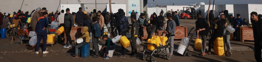 Palestinos desplazados esperan en fila para obtener el agua potable de una estación de agua en Tal Al-Sultan, Rafah