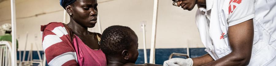François Idembe, enfermero de MSF, administra una inyección al hijo de Rutha, Bariki, con el objetivo de reducir su fiebre alta y aliviar la infección que le causa malestar. Hospital de Drodro, provincia de Ituri, RDC