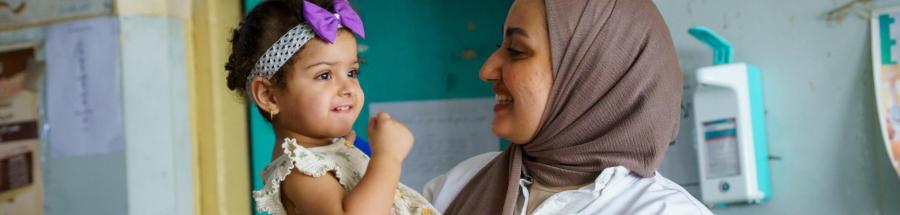 Una trabajadora del personal sanitario de MSF sostiene en brazos a Zahraa, una niña pequeña que recibe atención de seguimiento en el centro de salud Al-Mahdi, en Sadr City, Bagdad.