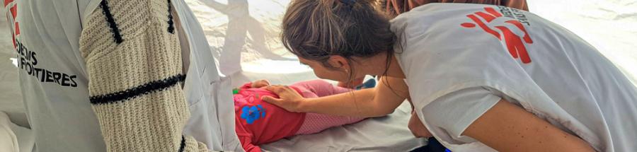 Megan Hughes, enfermera, examina a un bebé de 9 meses.