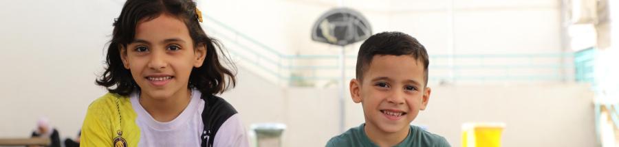 Omar está sentado con su hermana en el patio del hospital de cirugía reconstructiva de Amán, Jordania. 