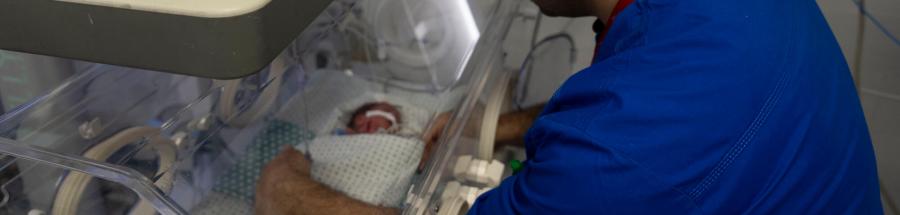 Un miembro del personal del Hospital Al-Helou, en Ciudad de Gaza, Palestina, examina a un recién nacido con bajo peso que se encuentra en una incubadora.