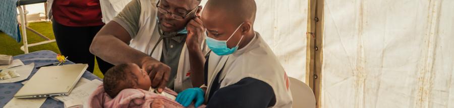 La consejera Nosisipho Zozi observa mientras el doctor Adebayo Mikail Abisola y la enfermera Silindelwe Khanyile atienden a un joven paciente en Musina, cuya familia huyó de los disturbios contra los inmigrantes en Sudáfrica.
