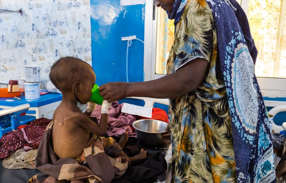 Una madre alimenta a su hijo con desnutrición grave con leche terapéutica en el Centro de Alimentación Terapéutica para Pacientes Hospitalizados (ITFC) del Hospital Regional Bay, apoyado por MSF en Baidoa, Somalia. © Yahya Mohammed/MSF