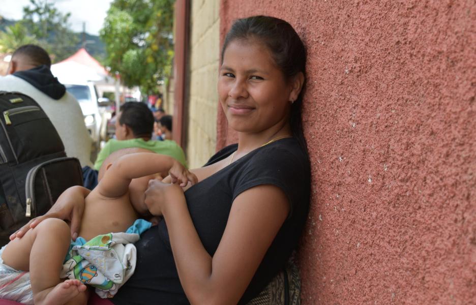 La hija mayor de la familia Brito amamanta a su hijo mientras espera que su familia reciba consulta médica.