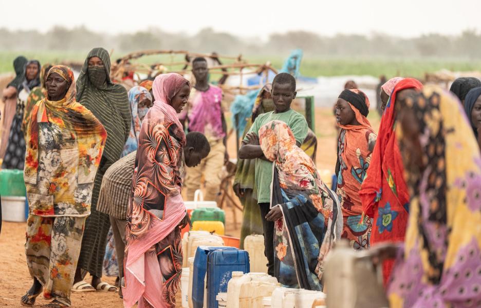 Un grupo de personas sudanesas refugiadas en el campo chadiano de Ecole, en Adré (este de Chad), hacen cola para recoger agua potable de una fuente.