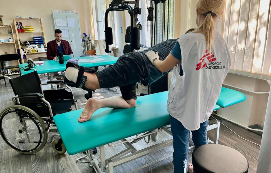MSF physiotherapist with war-wounded patient