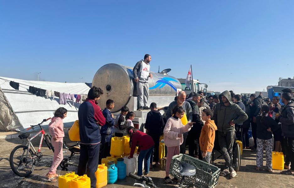Youssef Al-Khishawi, agente de agua y saneamiento de MSF, supervisa una distribución de agua desde la plataforma de un camión de MSF en la zona de Tal Al-Sultan