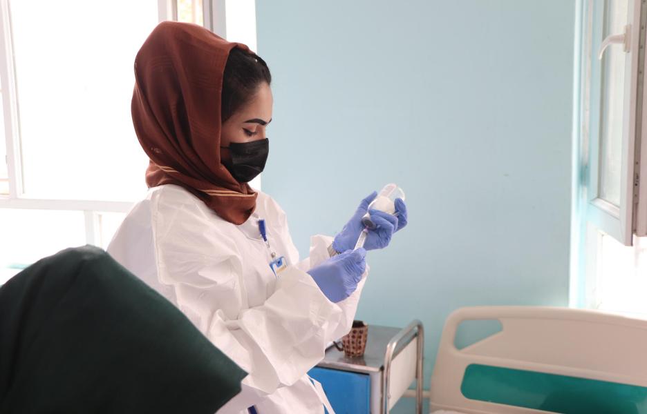 Farida, enfermera de MSF, extrae el contenido de un vial para inyectar a un paciente en la sala de aislamiento de sarampión del Hospital Regional de Mazar-i-Sharif.