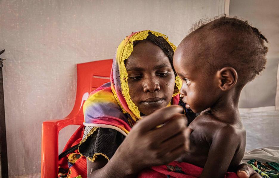 Una mujer y su hijo en el centro de alimentación terapéutica del campo de Metche