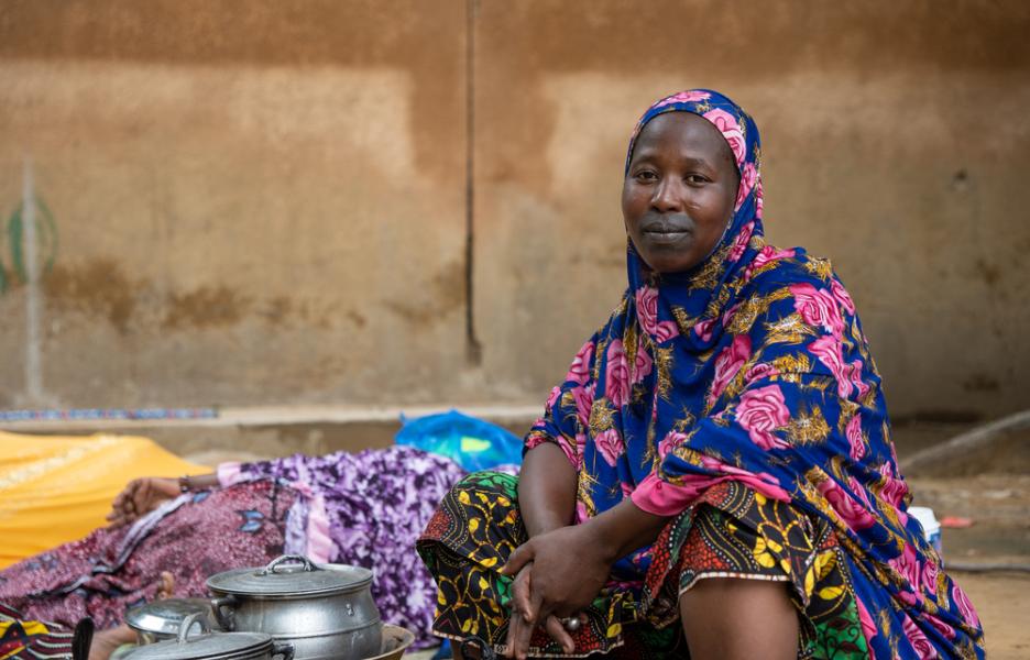 Una acompañante de una paciente hospitalizada cocina en el patio del centro de salud. Ténenkou, Mali.