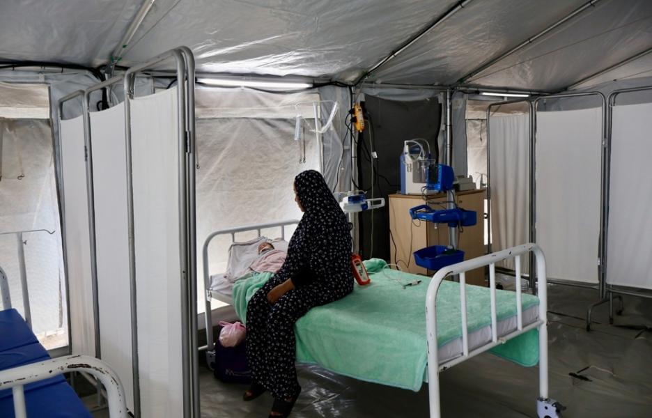 Faten, una madre de 39 años, junto a su bebé, que sufre una grave infección respiratoria. Hospital de campaña de MSF en Deir Al Balah