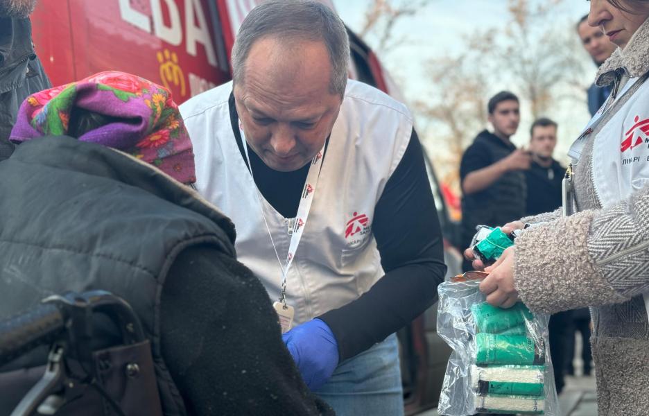 El médico de MSF Oleksandr Hontariev realiza un tratamiento quirúrgico inicial en el brazo de un paciente