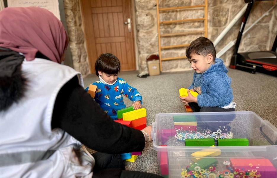 Ola, consejera de MSF, interactúa con los niños a través del juego durante una sesión de intervención familiar