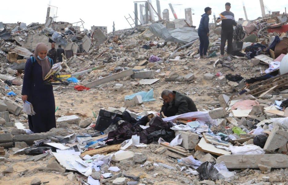Palestinos buscando sus pertenencias entre las ruinas de Rafah.