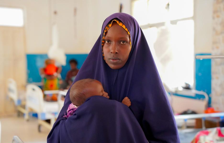 Amina Adan, de 22 años, acuna suavemente a su hija de 6 meses, Fardowsa Dahir, en la sala de pediatría del Hospital Regional Bay de Baidoa 