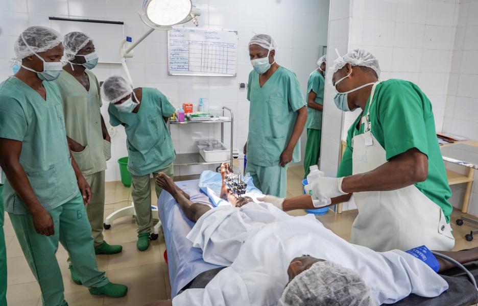 Un equipo médico realiza una intervención quirúrgica a un joven herido de bala.