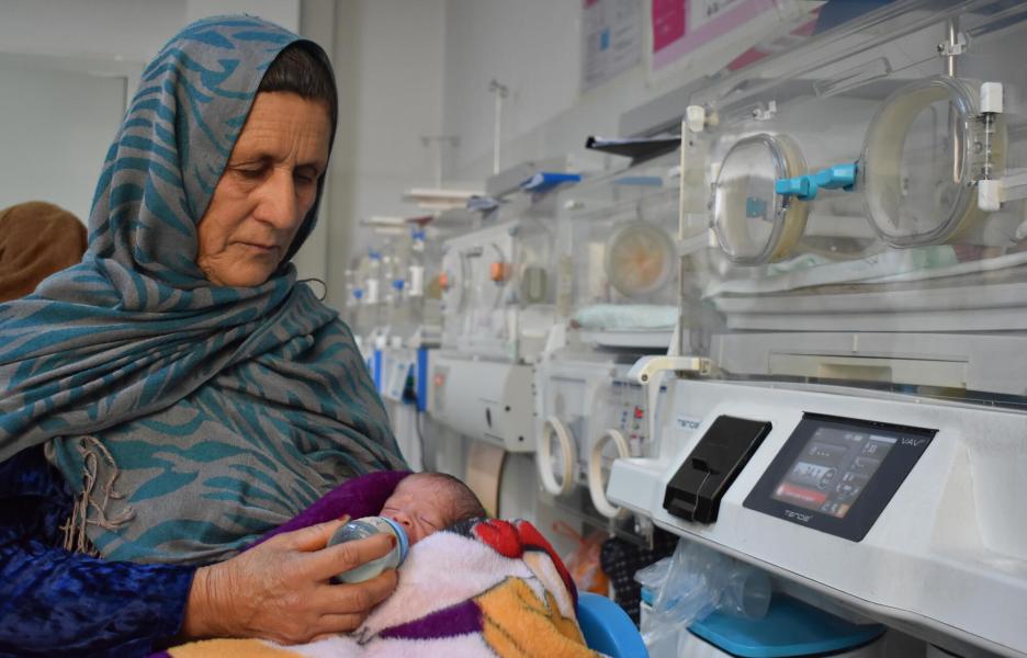 Reza Gul da el biberon a su nieto prematuro. Hospital de Marzar-i-Sharif.