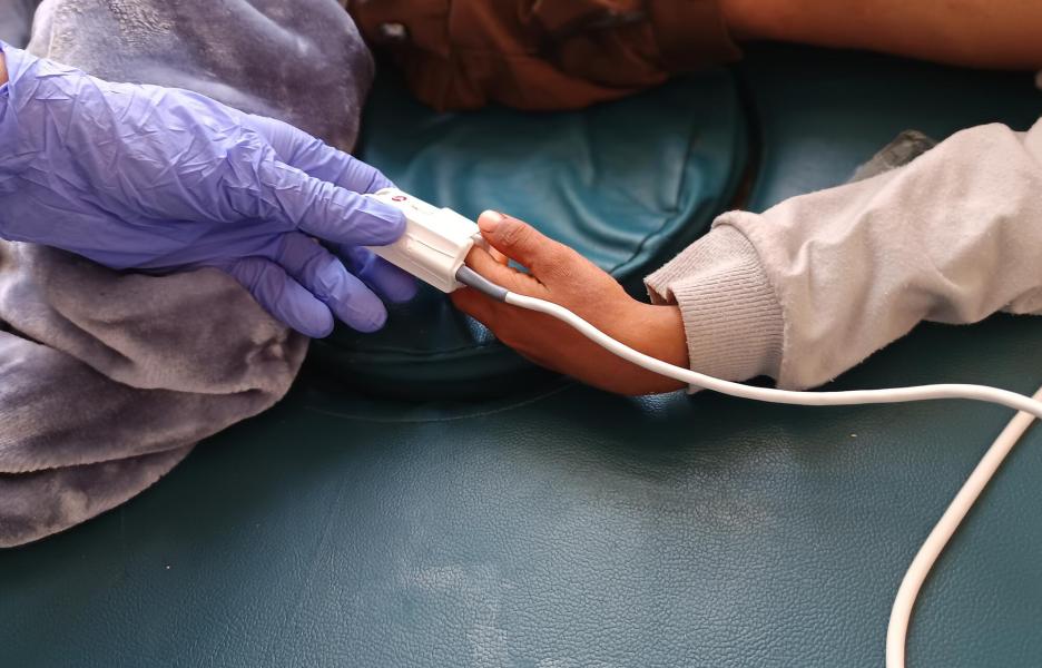 Una enfermera registra los signos vitales de un paciente con sarampión