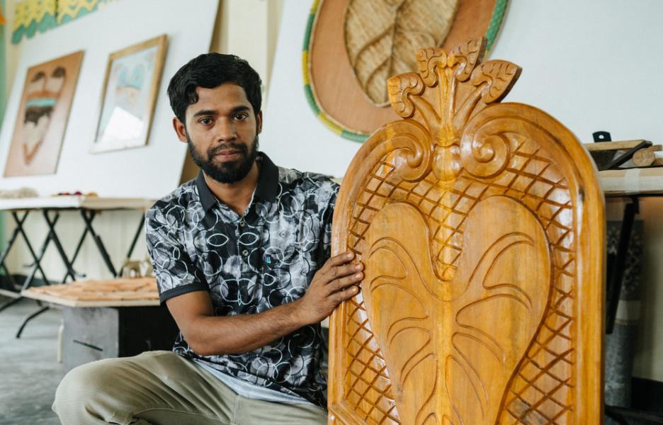 Mohamed Colim, carpintero, con su creación en forma de hoja de taro.