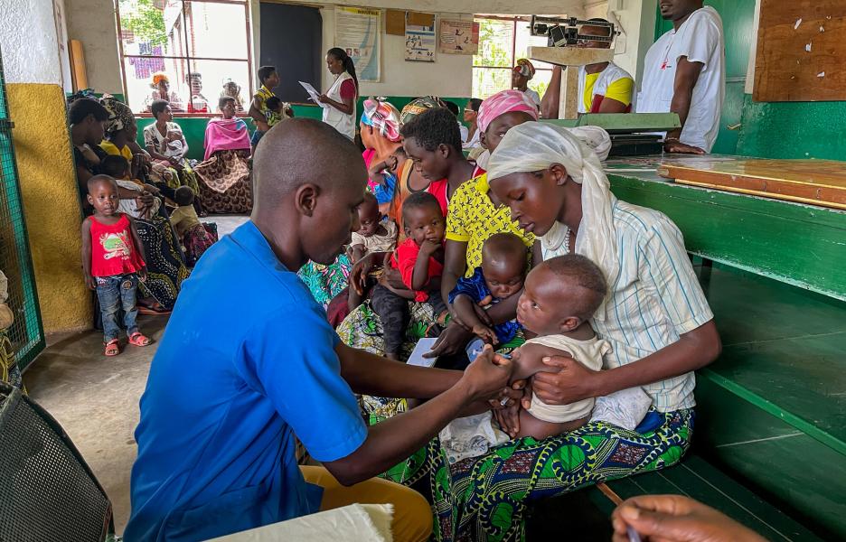 Uno de los enfermeros vacuna a un bebé. 