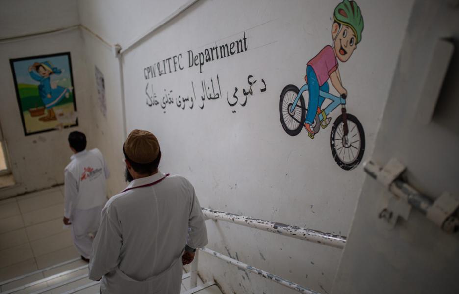 El personal baja las escaleras hacia la sala de pediatría y el centro de nutrición terapéutica para pacientes hospitalizados del Hospital Boost, en Afganistán.