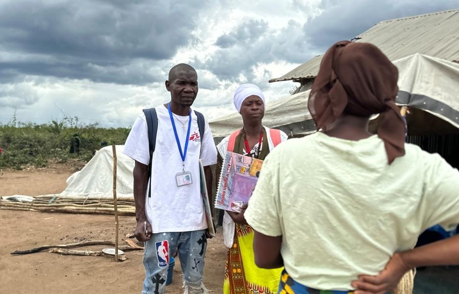 Los promotores de salud de MSF Jorge Francisco Matias y Sinae Mussa hablan con una mujer durante una visita domiciliaria en el campamento de desplazados de Lianda, en el distrito de Mueda.