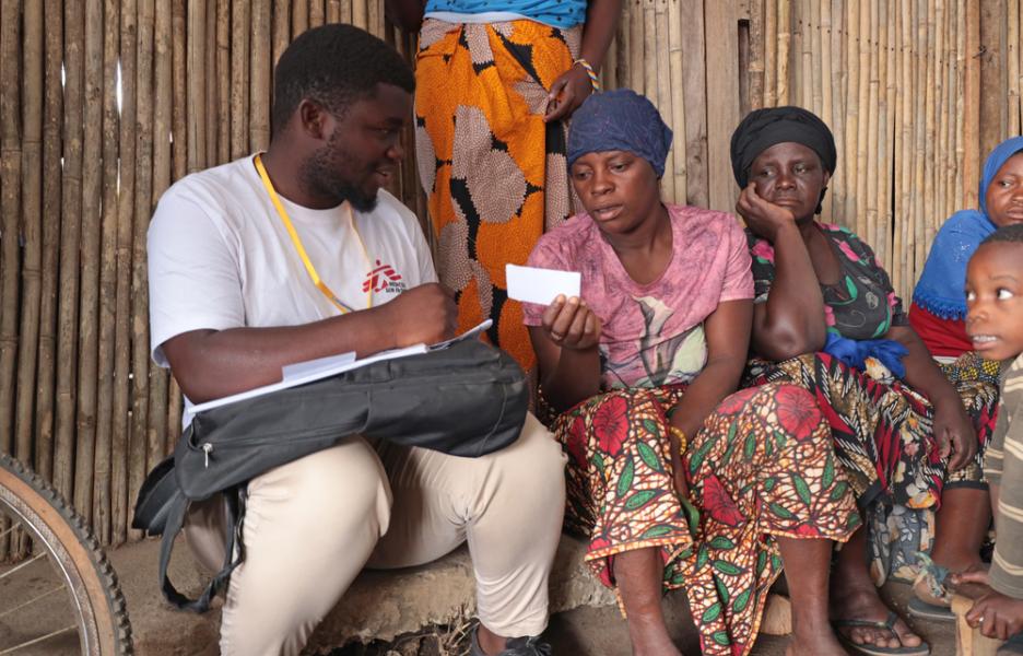 El promotor de salud de MSF Issa Manzi Makaburi entrega un documento de derivación a una mujer en el campamento de desplazados de Lianda, en el distrito de Mueda.