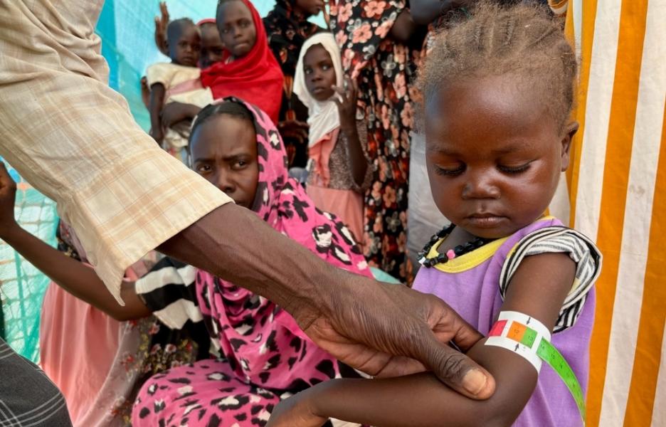 Un miembro de MSF mide la circunferencia del brazo de Nouran Abdallah, de dos años, que huyó de El Fasher el 11 de octubre con su familia. La medición muestra desnutrición aguda moderada.