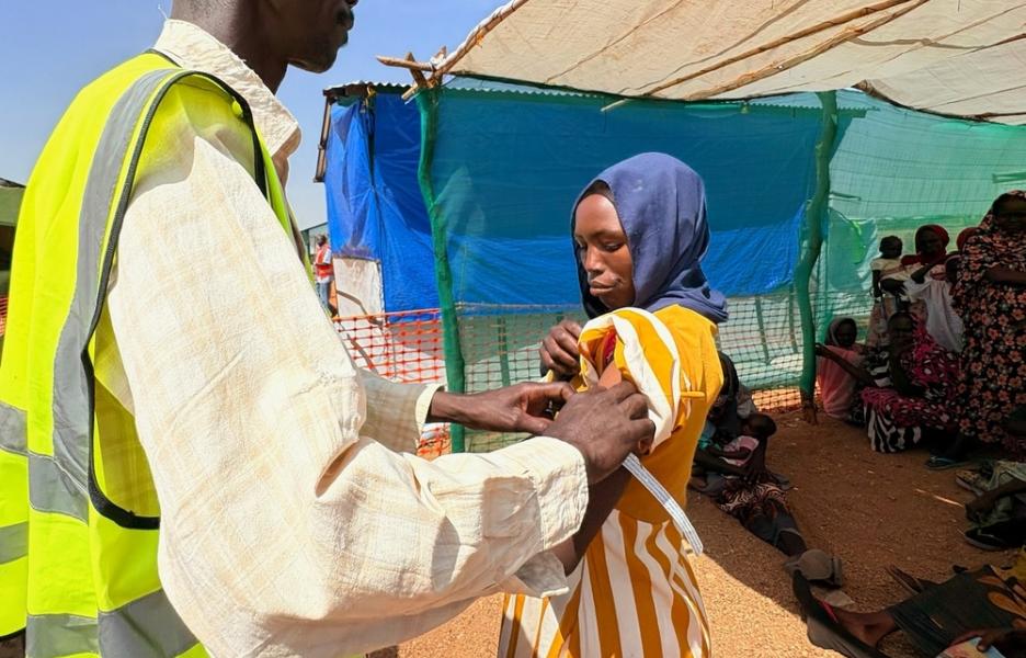 Un miembro del personal de MSF mide la circunferencia braquial de Hawa Abdallah para comprobar su nivel de desnutrición