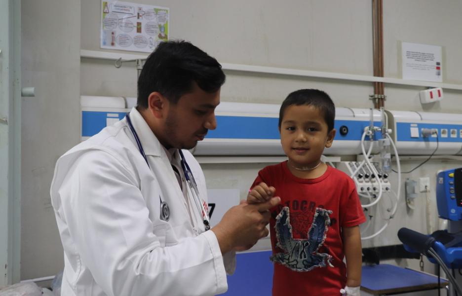 Yusuf habla con su médico mientras recibe tratamiento en la unidad de cuidados intensivos pediátricos de MSF en el Hospital Regional Abo Ali Sina, en Mazar i Sharif (Afganistán).
