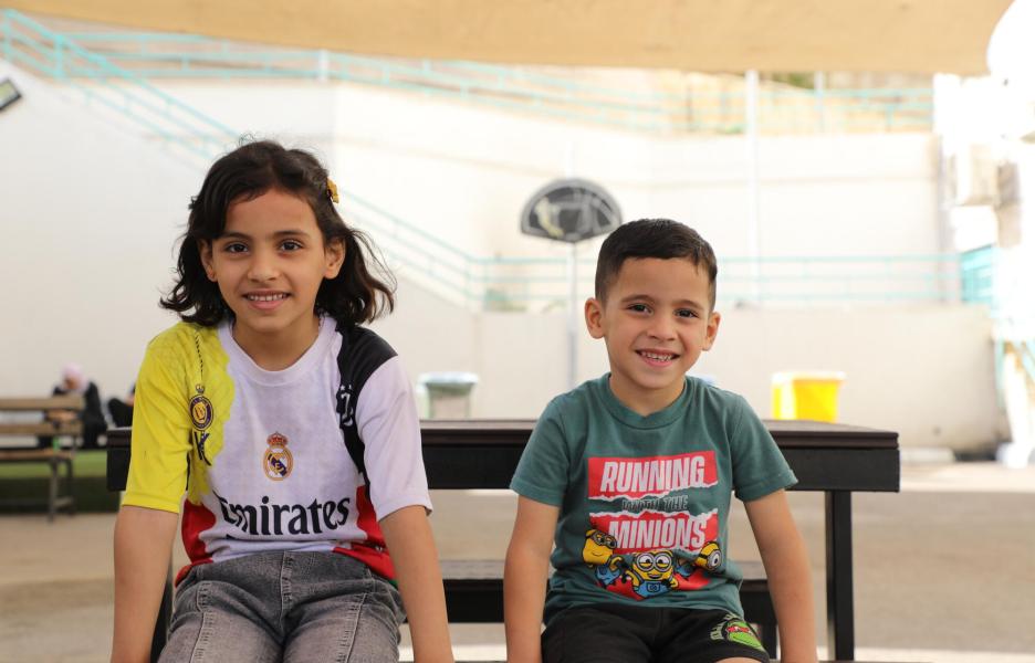 Omar está sentado con su hermana en el patio del hospital de cirugía reconstructiva de Amán, Jordania. 