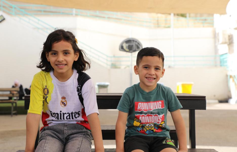 Omar está sentado con su hermana en el patio del hospital de cirugía reconstructiva de Amán, Jordania. 