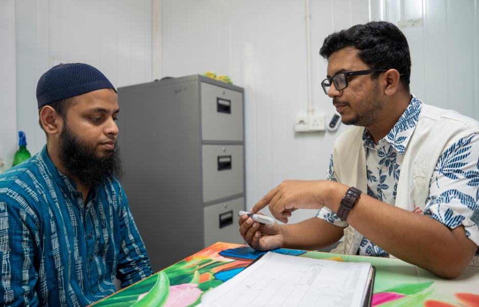 Un paciente rohinyá con diabetes en una consulta médica. El médico de MSF le muestra una pluma de insulina. Cox's Bazar, Bangladesh.